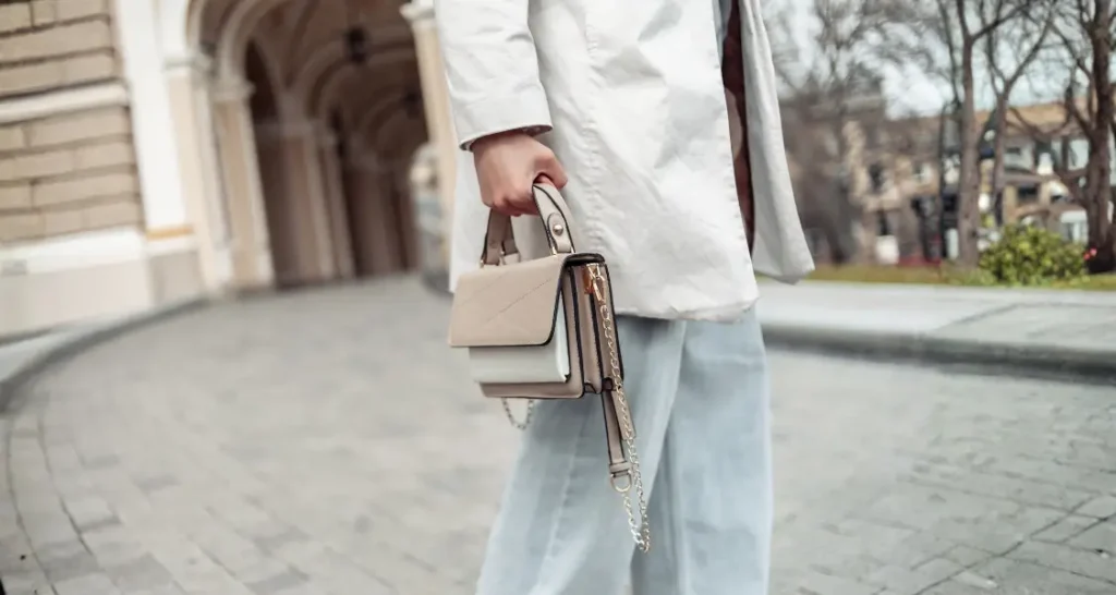 woman holding neutral handbag brestyle